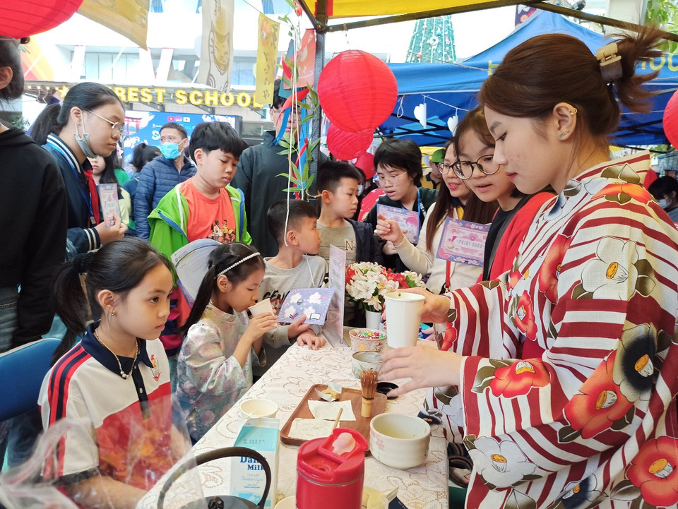 Trà đạo, một trong những nét văn hóa đặc trưng của Nhật Bản thu hút rất đông các em học sinh trải nghiệm. (Ảnh: Phạm Mai/Vietnam+)