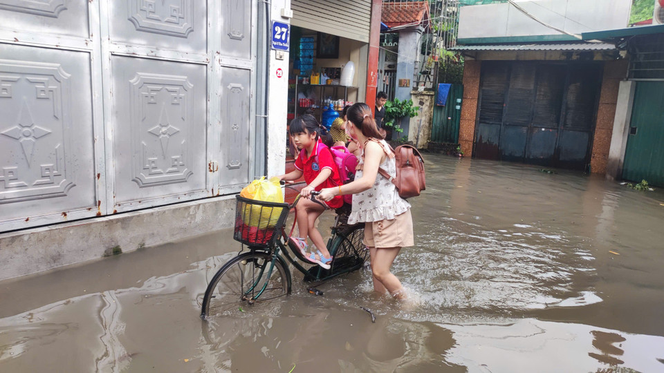 Nhiều gia đình không thể dắt xe máy ra, buộc phải dùng đến xe đạp để đưa con đi học. (Ảnh: Hoài Nam/Vietnam+)