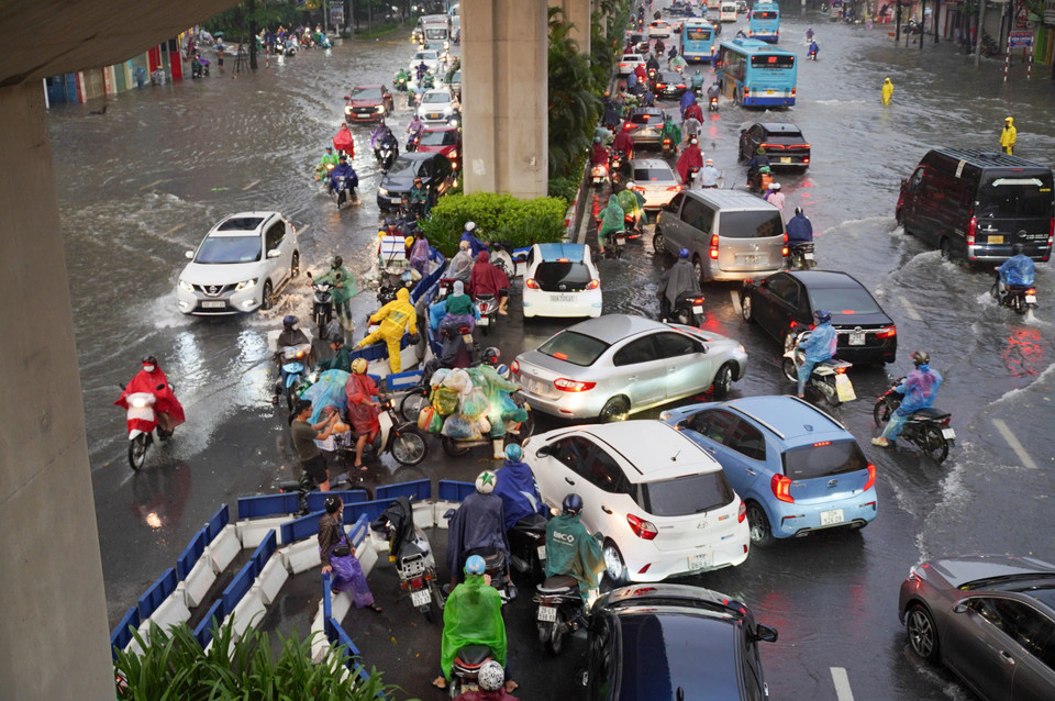Các phương tiện phải dồn sang phần đường ít ngập để di chuyển, gây ách tắc giao thông. (Ảnh: PV/Vietnam+)