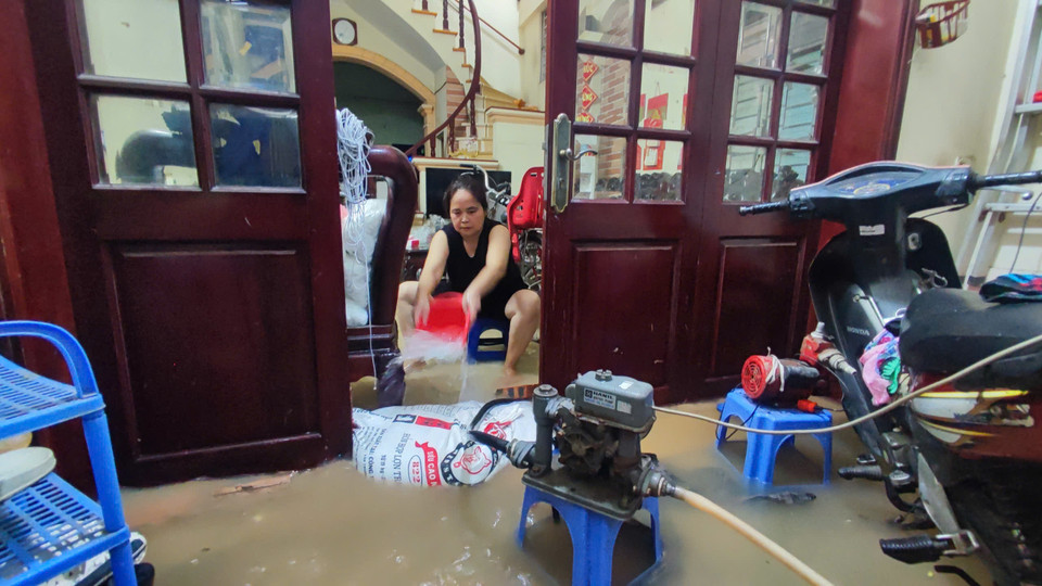 Ghi nhận tại một hộ gia đình thuộc xã Tân Triều, huyện Thanh Trì nước ngập vào thềm, phải kết hợp vừa bơm, vừa tát nước ra ngoài. (Ảnh: Hoài Nam/Vietnam+)