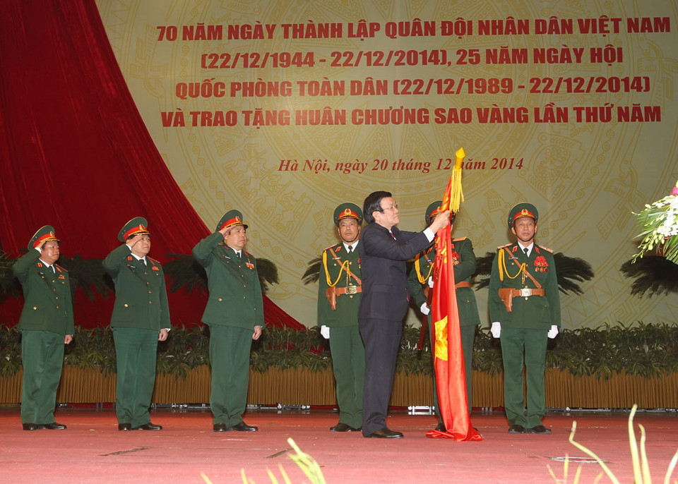 Chủ tịch nước Trương Tấn Sang gắn Huân chương Sao Vàng lên lá cờ truyền thống của Quân đội nhân dân Việt Nam. (Ảnh: Trí Dũng/TTXVN)