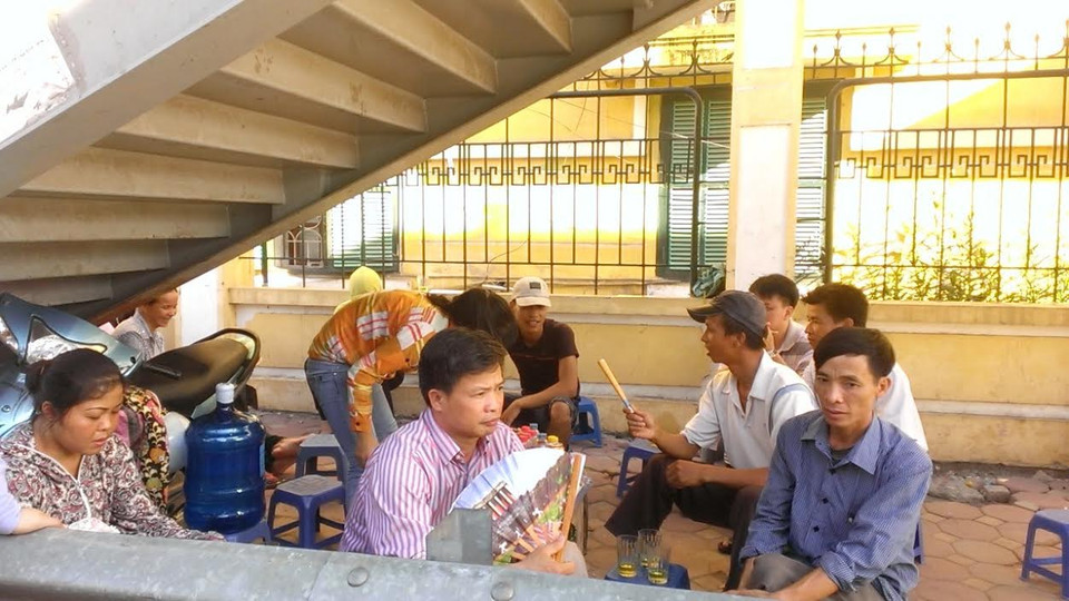 Bóng râm hiếm hoi dưới chân cầu vượt dành cho người đi bộ được tận dụng để bán nước, làm điểm chờ cho phụ huynh. (Ảnh: Phạm Mai/Vietnam+)