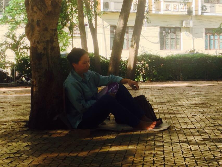 Phụ huynh ngồi đợi con dưới bóng cây tại trường Đại học Sư phạm Hà Nội. (Ảnh: Sơn Bách/Vietnam+)