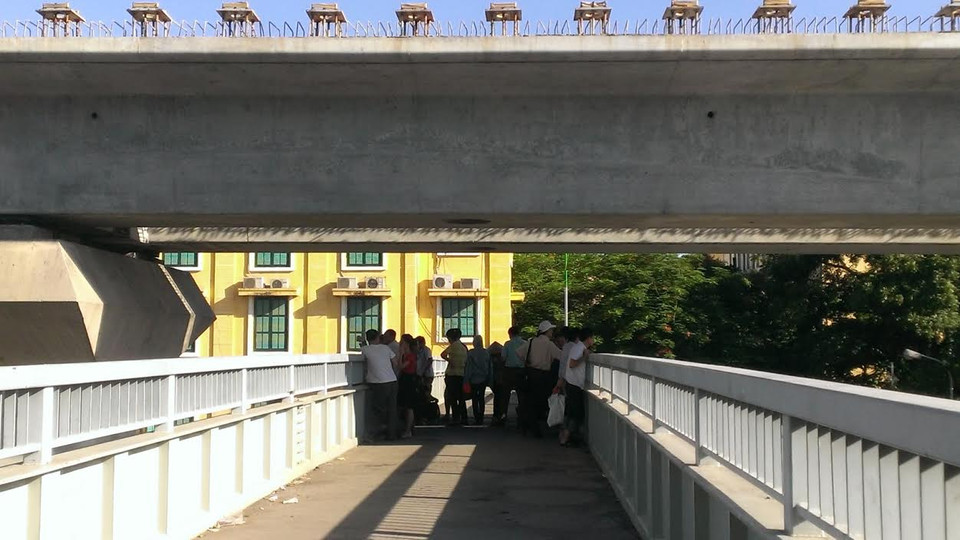 Không có bóng cây như tại Đại học Sư phạm Hà Nội, tại trường Đại học Khoa học Xã hội và Nhân văn, phụ huynh phải tận dụng bóng râm ít ỏi từ đường cao tốc trên cao chiếu xuống cầu vượt dành cho người đi bộ. (Ảnh: Phạm Mai/Vietnam)