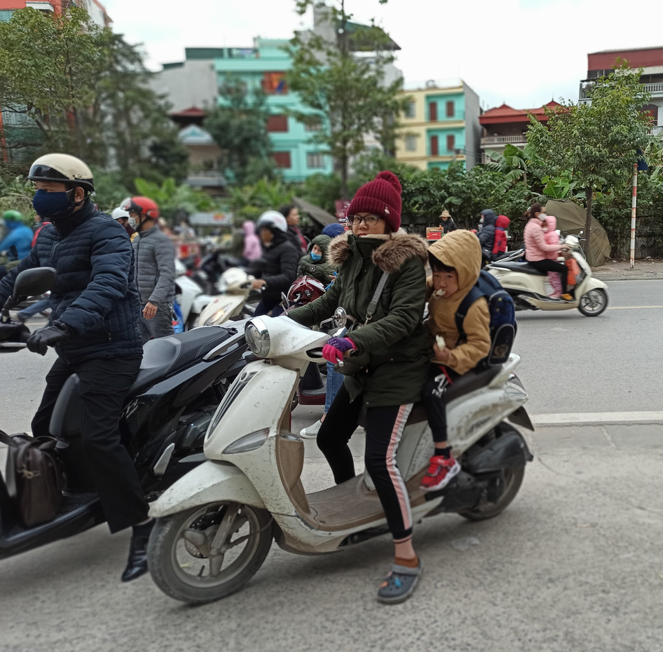 Dậy muộn, học sinh này ăn sáng ngay trên xe. (Ảnh: PM/Vietnam+)