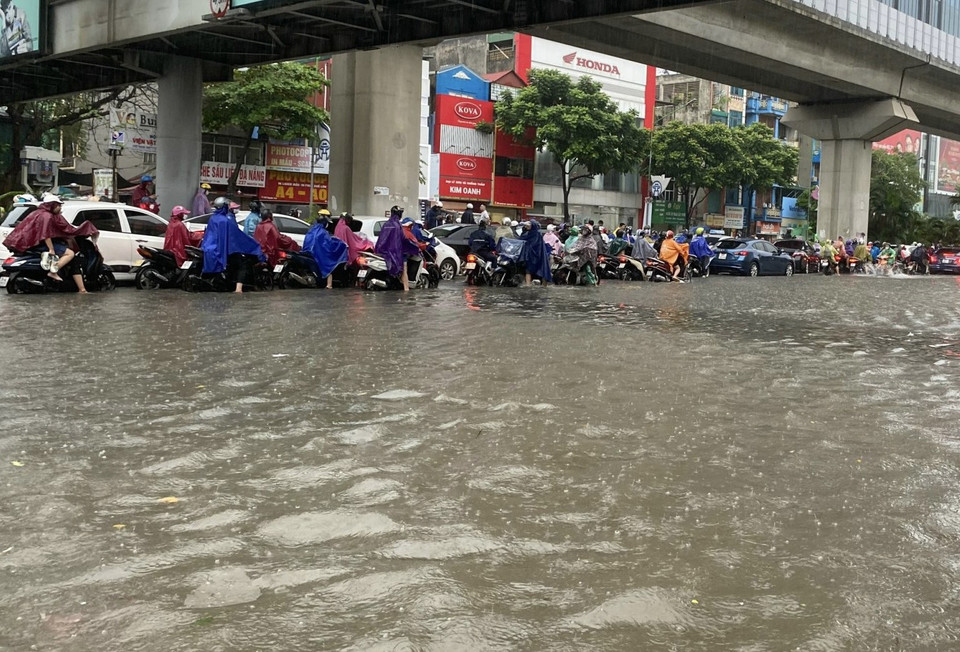 Dòng xe nườm nượp trên đường Nguyễn Trãi. Nước đã ngập quá nửa bánh xe máy. (Ảnh: Minh Hiếu/Vietnam+)
