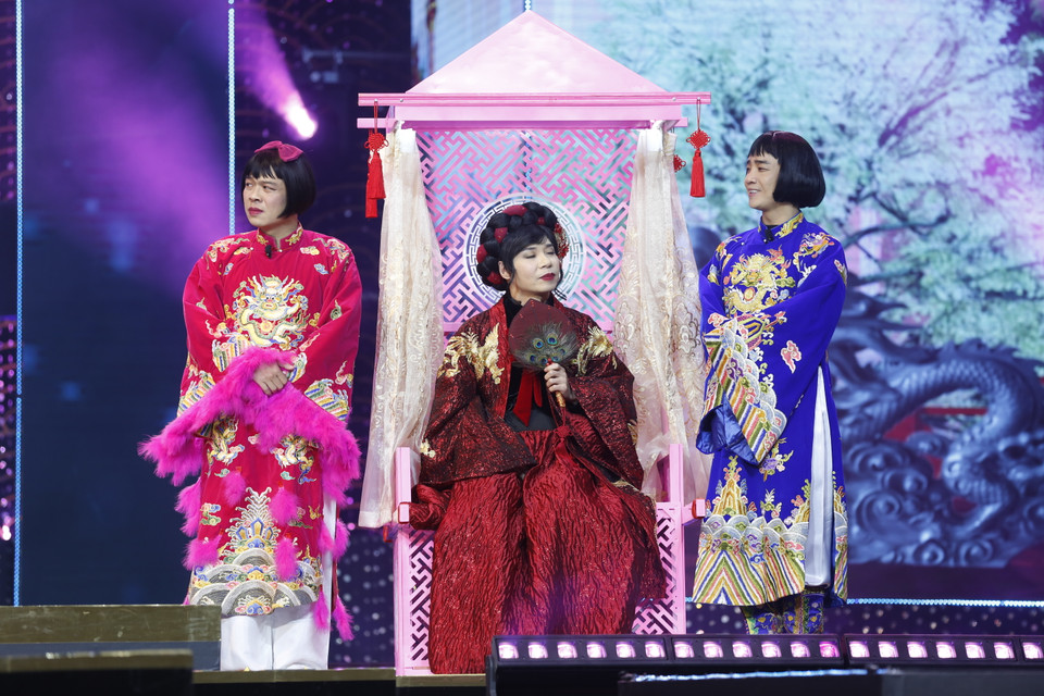 Sự trở lại của Công Lý sau một năm phải vắng mặt vì lý do sức khỏe là yếu tố khiến khán giả đón đợi. Năm nay, Công Lý ngồi kiệu hoa ra sân khấu, vẫn giả gái xinh đẹp như trước đây, nhưng từ lối trang điểm tới trang phục đều 'hiền thục' hơn phiên bản những năm trước. (Ảnh: CTV/Vietnam+) 