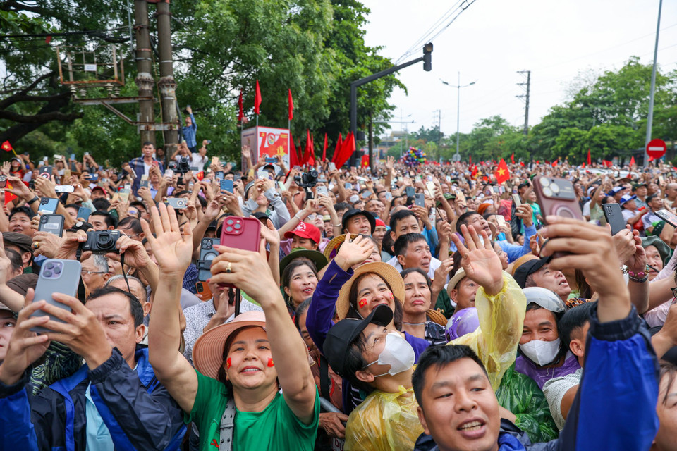 Tuy vậy, rất đông người dân không quản ngại mưa gió, tập trung từ sáng sớm dọc theo tuyến đường của đoàn diễu binh diễu hành. (Ảnh: Minh Sơn/Vietnam+)