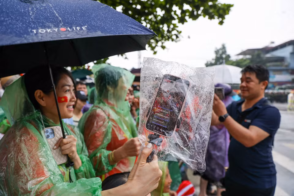 Người dân chụp túi bóng bảo vệ điện thoại, quay truyền hình trực tiếp (livestream). (Ảnh: Minh Sơn/Vietnam+)