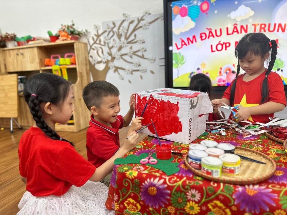 Học sinh Trường Mầm non Hoa Hướng Dương được thầy cô hướng dẫn tự làm đầu lân từ thùng carton. (Ảnh: NTCC)