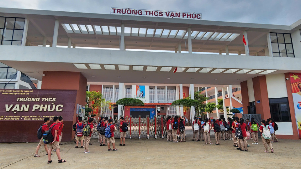 Học sinh Trường Trung học cơ sở Vạn Phúc, Thanh Trì đến trường sau một tuần phải nghỉ. Bão Yagi đã làm ngập toàn bộ sân trường và các tuyến đường đến trường. (Ảnh: PV/Vietnam+)