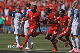 Niềm vui của các cầu thủ Canada sau khi có bàn gỡ. (Ảnh: AFP/TTXVN)