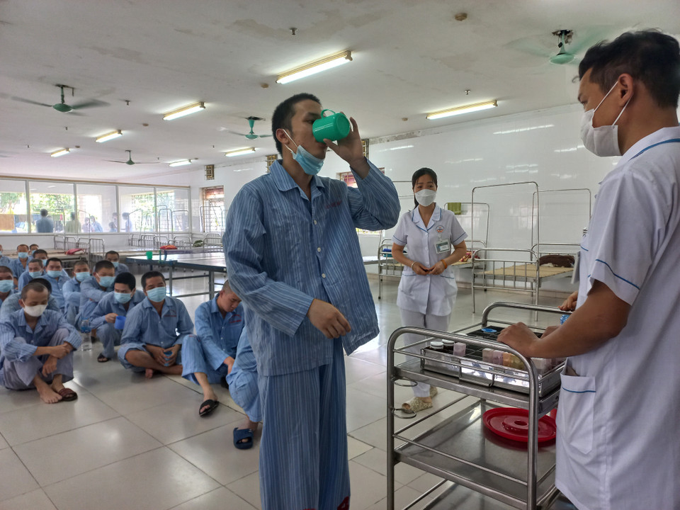 Bệnh nhân uống thuốc dưới sự giám sát của nhân viên y tế. (Ảnh: PV/Vietnam+)