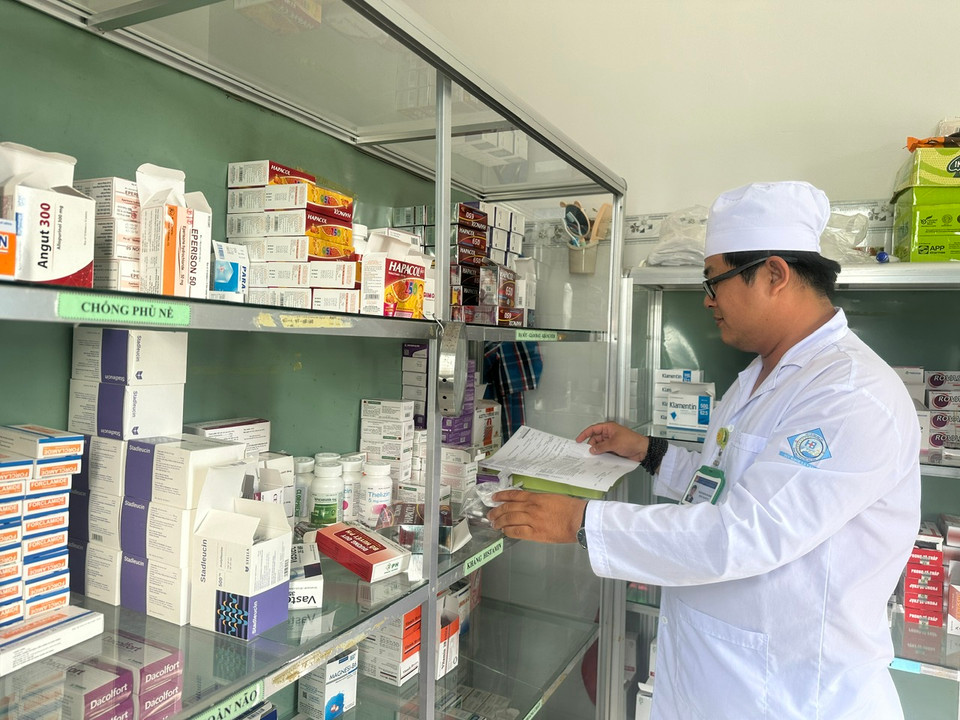 Nhân viên Trạm Y tế xã Vĩnh Hậu A, huyện Hòa Bình, tỉnh Bạc Liêu lấy đơn thuốc cấp phát thuốc cho người bệnh. (Ảnh: T.G/Vietnam+)