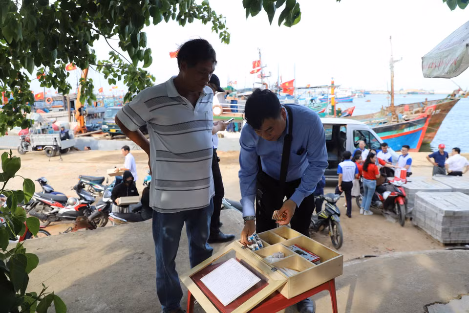 Ngay sau khi trao tặng tủ thuốc, các bác sỹ hướng dẫn chi tiết về các loại thuốc, dụng cụ y tế cho bà con ngư dân. (Ảnh: PV/Vietnam+)