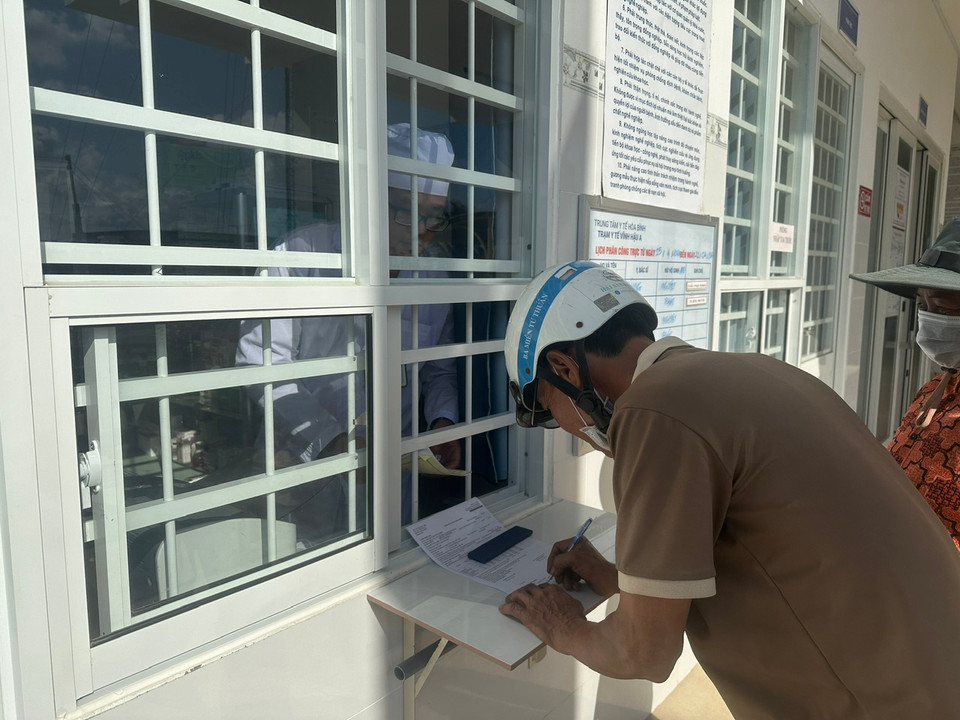 Người bệnh làm thủ tục nhận thuốc bảo hiểm y tế tại Trạm Y tế. (Ảnh: T.G/Vietnam+)