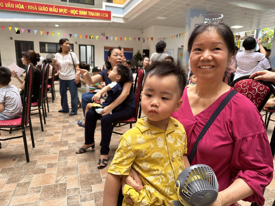 Người dân hân hoan đưa trẻ đi uống Vitamin A. (Ảnh: Thùy Giang/Vietnam+)