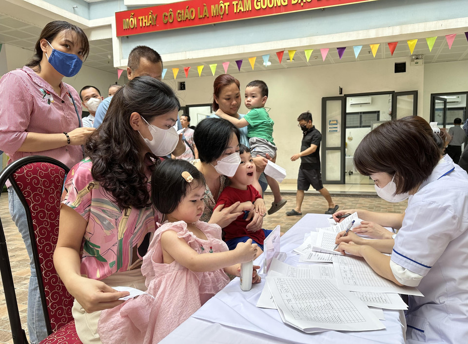 Làm thủ tục đăng ký cho trẻ trước khi vào uống Vitamin A. (Ảnh: Thùy Giang/Vietnam+)
