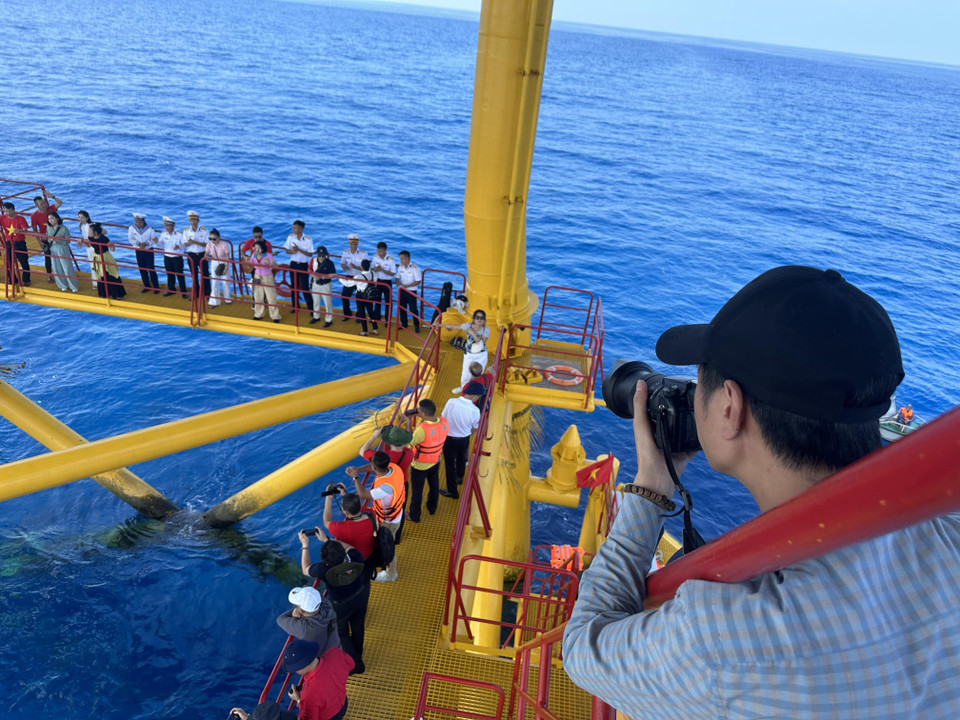 Nhà báo Nguyễn Quang Minh - Báo Tiền phong chụp ảnh đoàn công tác trên Nhà giàn DK1 Phúc Tần. (Ảnh: PV/Vietnam+)