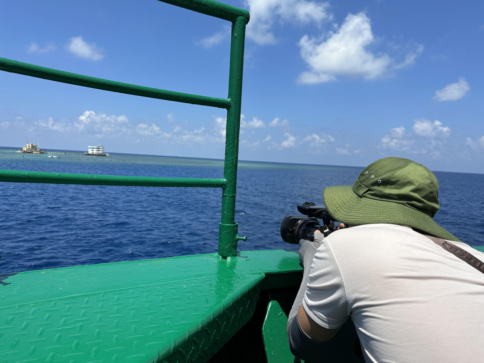 Có những “cung đường” khó khăn như lên nhà giàn, cả biên tập và quay phim giữ gìn máy móc hơn cả bản thân mình. (Ảnh: Thùy Giang/Vietnam+)