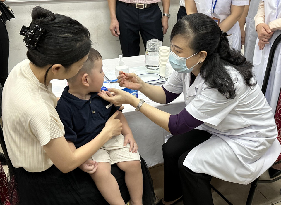 Bộ trưởng Bộ Y tế Đào Hồng Lan cho trẻ uống Vitamin A. (Ảnh: Thùy Giang/Vietnam+)