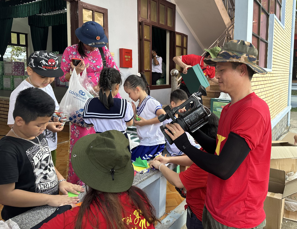 Quay phim Văn Hồng Thái - Đài Truyền hình Kỹ thuật số VTC ghi lại hình ảnh những em bé trên đảo Trường Sa. (Ảnh: PV/Vietnam+)