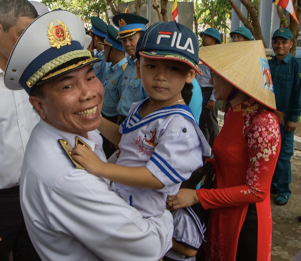 Chuẩn đô đốc Phạm Văn Hùng - Phó Tham mưu trưởng Quân chủng hải quân thăm hỏi sức khỏe một cháu bé trên đảo Trường Sa. (Ảnh: Tuấn Anh/Vietnam+)