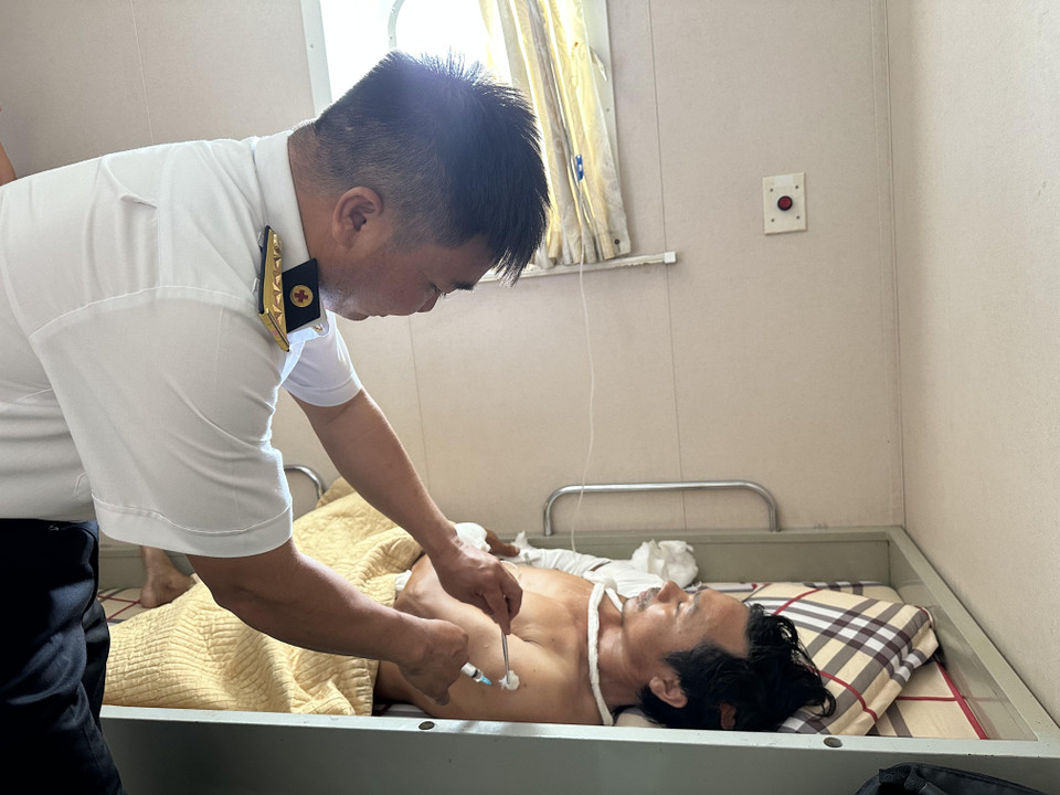 Nhân viên y tế chăm sóc cho ngư dân Hải trên hải trình vào đất liền. (Ảnh: Thùy Giang/Vietnam+)