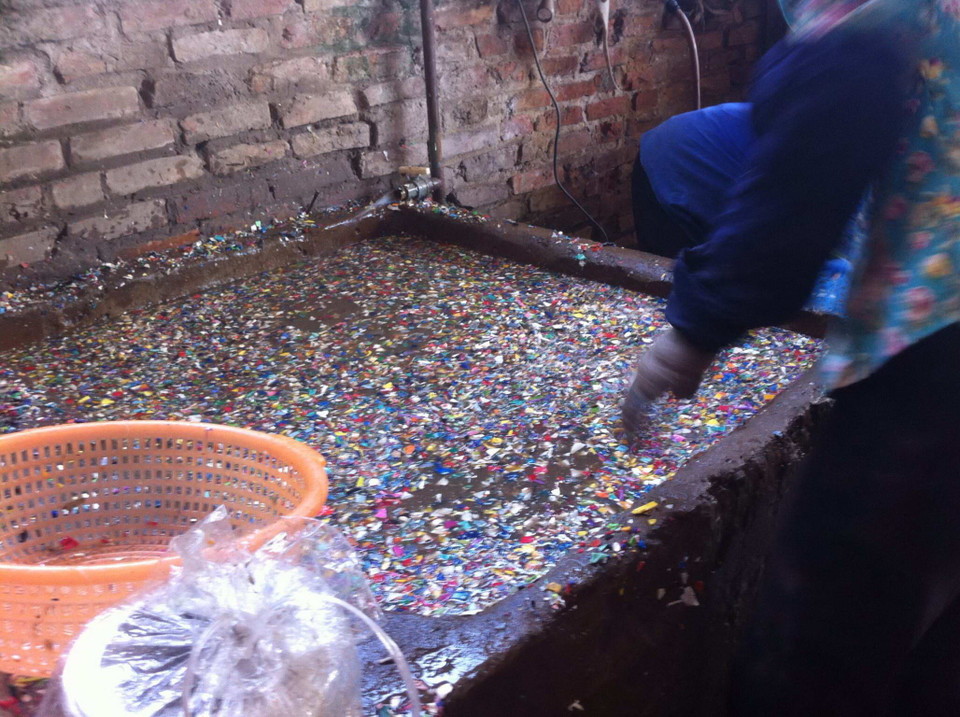 Tất cả các loại vỏ nhựa, gồm cả các thiết bị y tế sau khi được nghiền nhỏ sẽ được ngâm qua các bể như thế này. (Ảnh: Thùy Giang/Vietnam+)