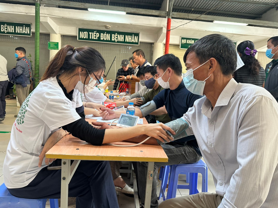 Nhân viên y tế đo huyết áp cho người dân tới khám sàng lọc phát hiện bệnh phổi tắc nghẽn mạn tính. (Ảnh: T.G/Vietnam+)