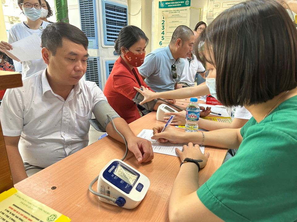 Nhân viên y tế đo huyết áp cho người dân tới khám. (Ảnh: T.G/Vietnam+)