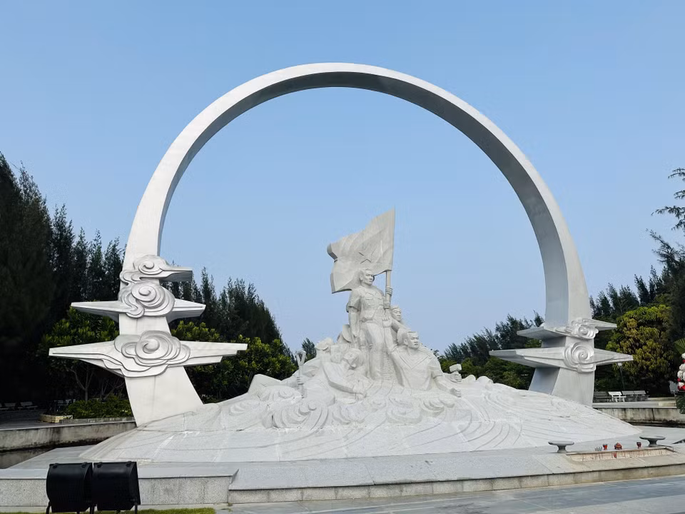 Tượng đài "Những người nằm lại phía chân trời" với hình tượng những người chiến sỹ Gạc Ma cầm ngọn cờ tựa lưng vào nhau hiện lên trong ánh nắng rực rỡ. (Ảnh: Thùy Giang/Vietnam+)