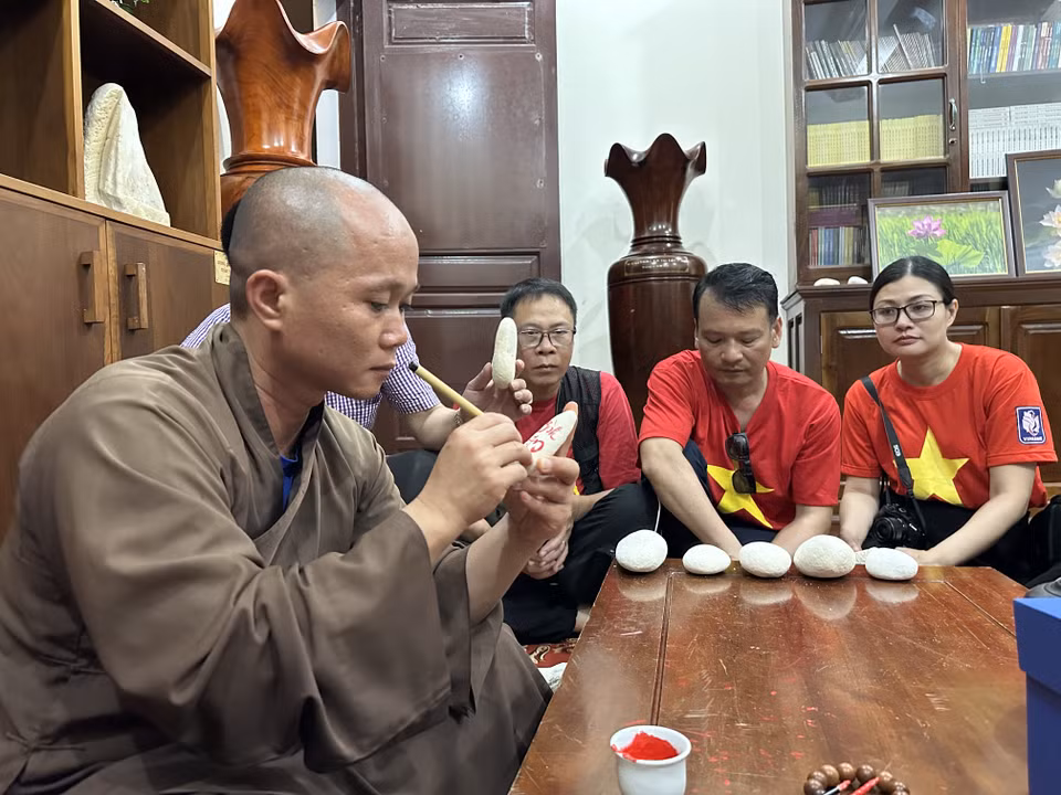 Đại đức Thích Nhuận Đạt trụ trì Chùa Trường Sa lớn tặng chữ cho các đoàn ra thăm đảo Trường Sa. (Ảnh: Thùy Giang/Vietnam+)