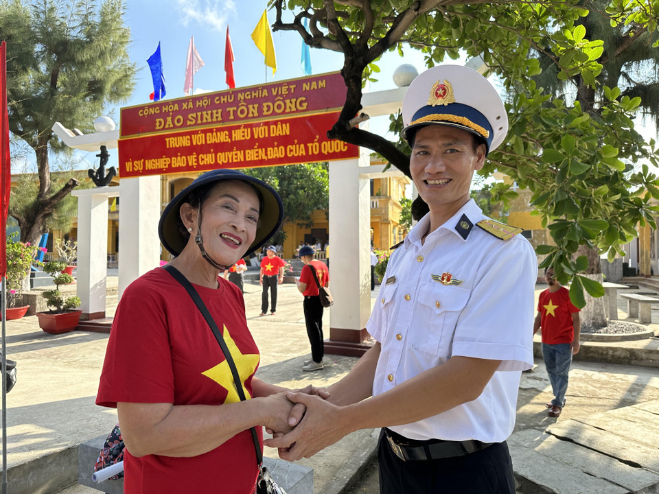 Bà Hoàng Thị Lai - Kiều bào Thái Lan phấn khởi khi chụp ảnh cùng với một chiến sỹ trên Đảo Sinh Tồn Đông. (Ảnh: Thùy Giang/Vietnam+)