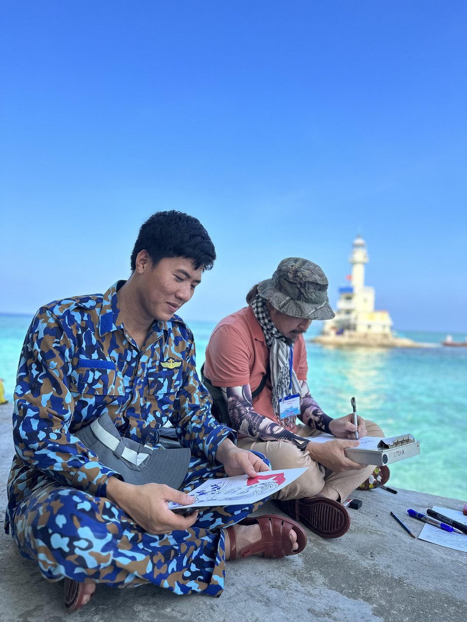 Người lính trẻ hân hoan nhận bức ký hoạ về mình. (Ảnh: Thùy Giang/Vietnam+)