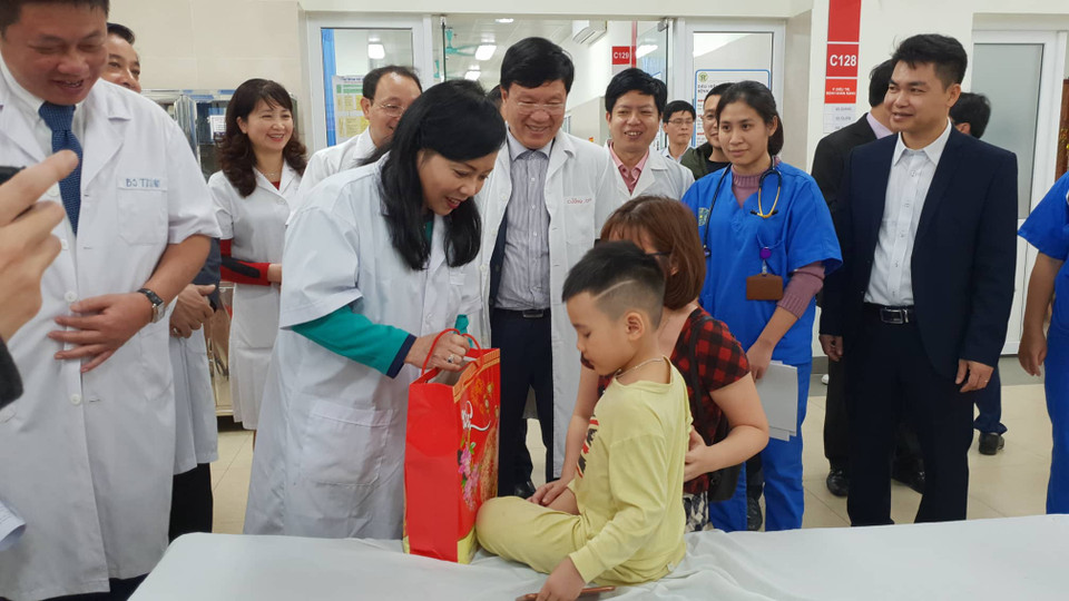 Bộ trưởng Bộ Y tế tặng quà cho bệnh nhân nhi. (Ảnh: T.G/Vietnam+)