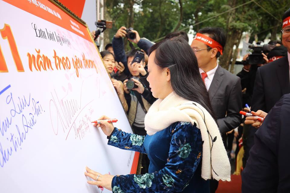 Bộ trưởng Bộ Y tế ký tên lưu niệm trên bức trướng Trái tim yêu thương. (Ảnh: PV/Vietnam+)