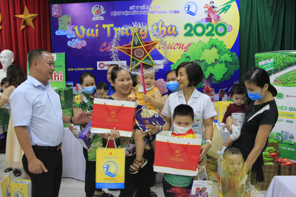 Bác sỹ phát quà cho các gia đình. (Ảnh: PV/Vietnam+)