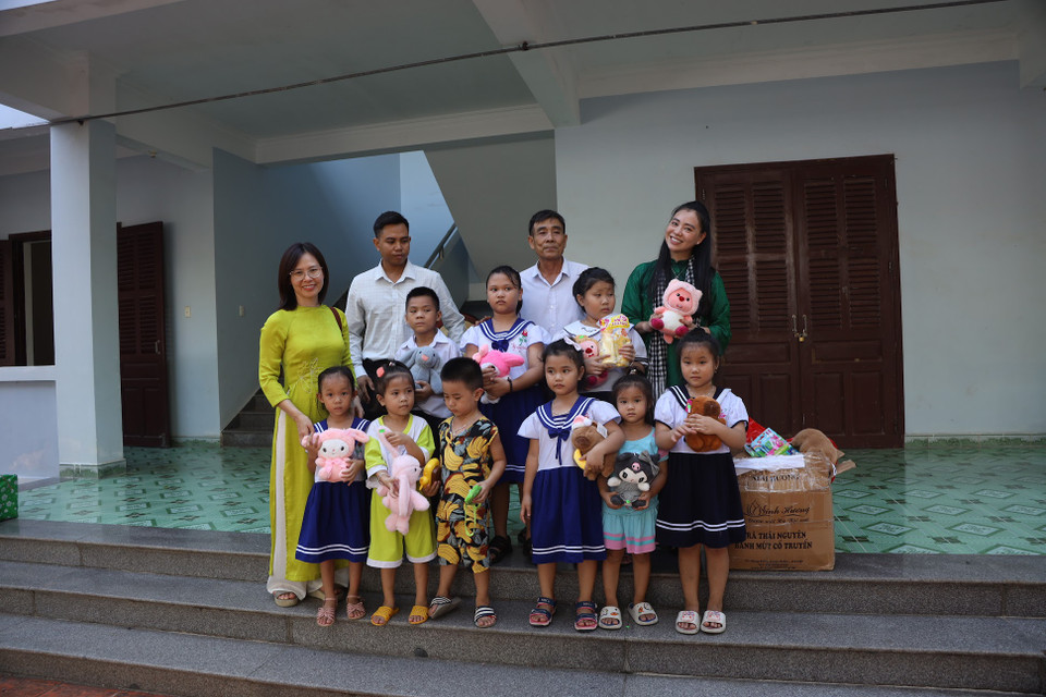 Các em nhỏ chụp ảnh lưu niệm với thành viên đoàn công tác. (Ảnh: Thu Minh/Vietnam+)