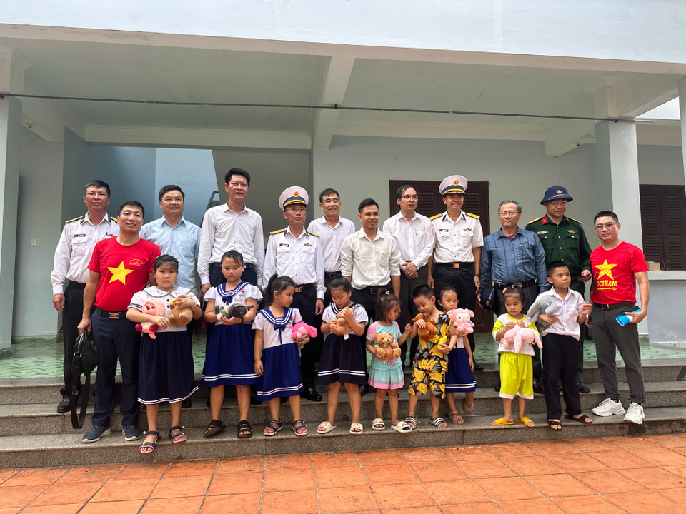 Lãnh đạo Đoàn công tác số 21 năm 2024 chụp ảnh lưu niệm với các em nhỏ trên đảo Trường Sa. (Ảnh: Thùy Giang/Vietnam+)