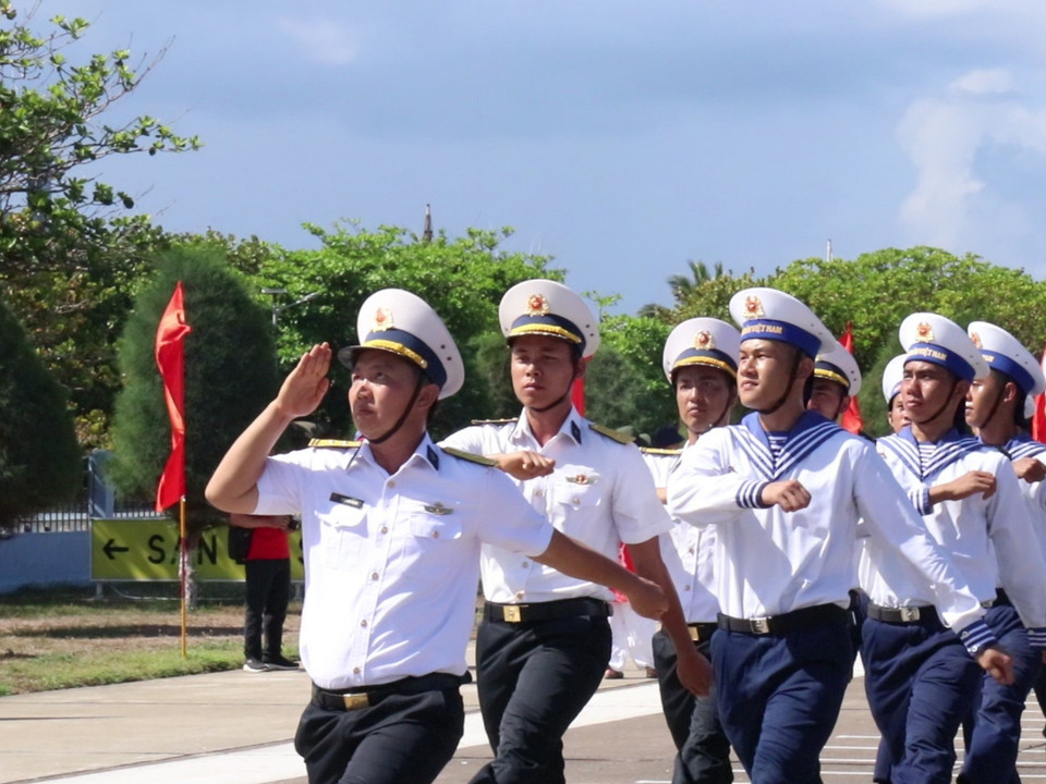 Cán bộ, chiến sĩ, nhân dân trên đảo Trường Sa theo đội hình khối thực hiện nghi thức duyệt đội ngũ. (Ảnh: PV/Vietnam+)