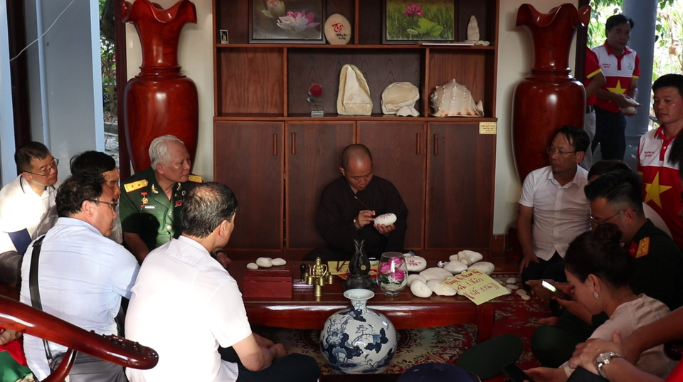 Đại đức Thích Nhuận Đạt trụ trì Chùa Trường Sa lớn tặng chữ cho những người đến Chùa xin chữ làm kỷ niệm. (Ảnh: PV/Vietnam+)