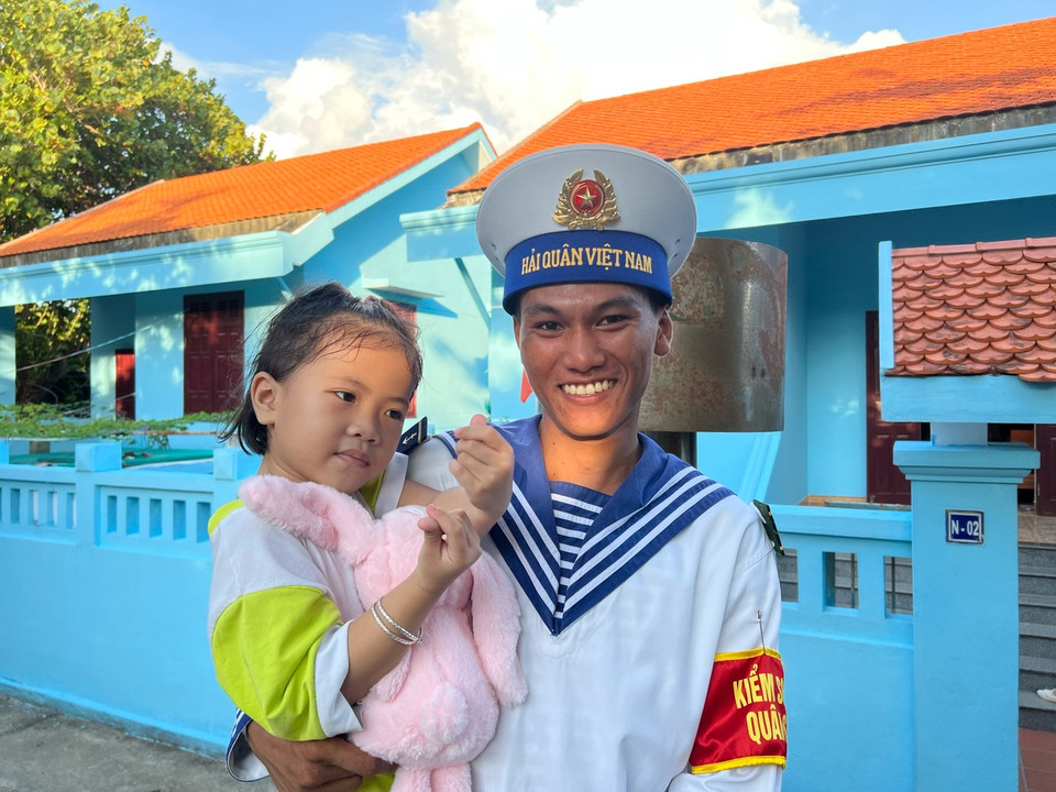 Em bé trên chụp cùng chiến sĩ trên đảo Trường Sa. (Ảnh: PV/Vietnam+)