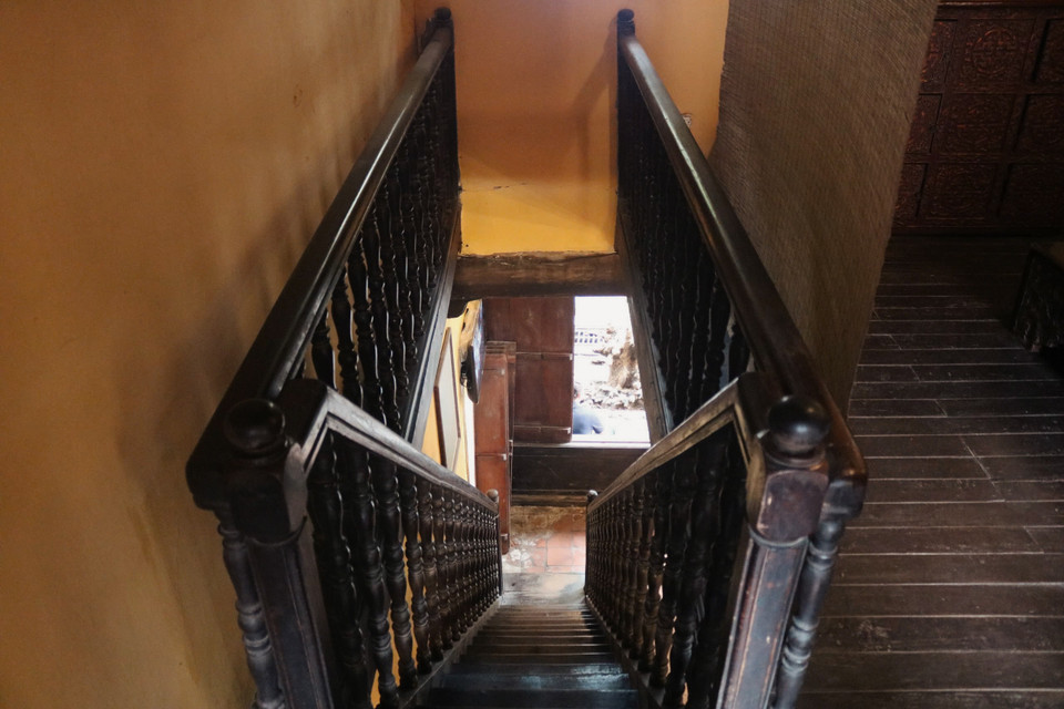 Chiếc cầu thang bằng gỗ dẫn lên tầng hai, nơi tiếp khách và thờ cúng. (Ảnh: Q.C/Vietnam+)