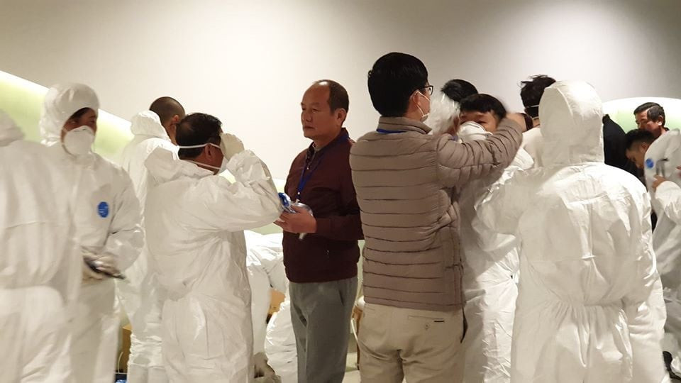 Để đưa công dân về khu vực cách ly an toàn, đội ngũ y bác sỹ, các lực lượng liên quan đã phòng hộ cẩn thận. (Ảnh: Vietnam+)