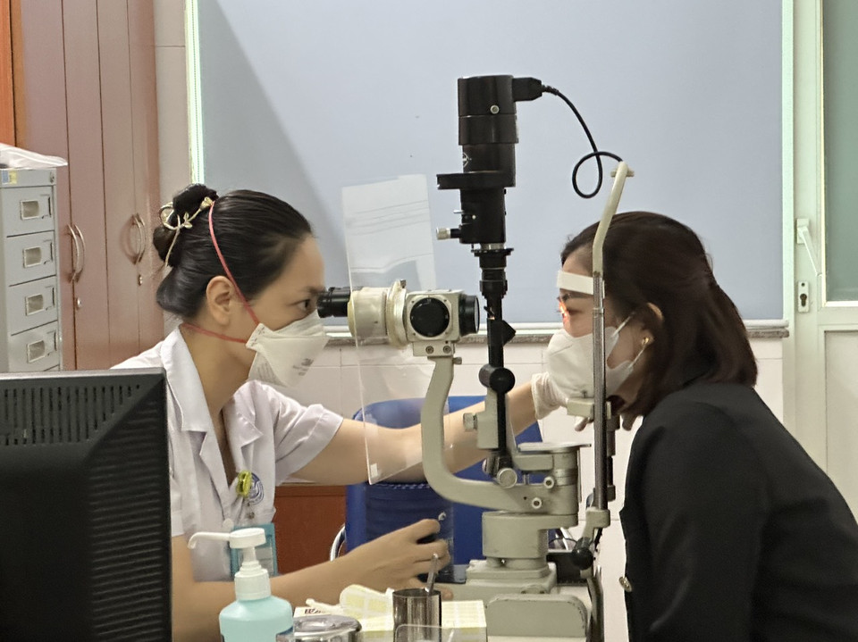 Bác sĩ Bệnh viện Mắt Trung ương khám cho một bệnh nhân đau mắt đỏ. (Ảnh: T.G/Vietnam+)