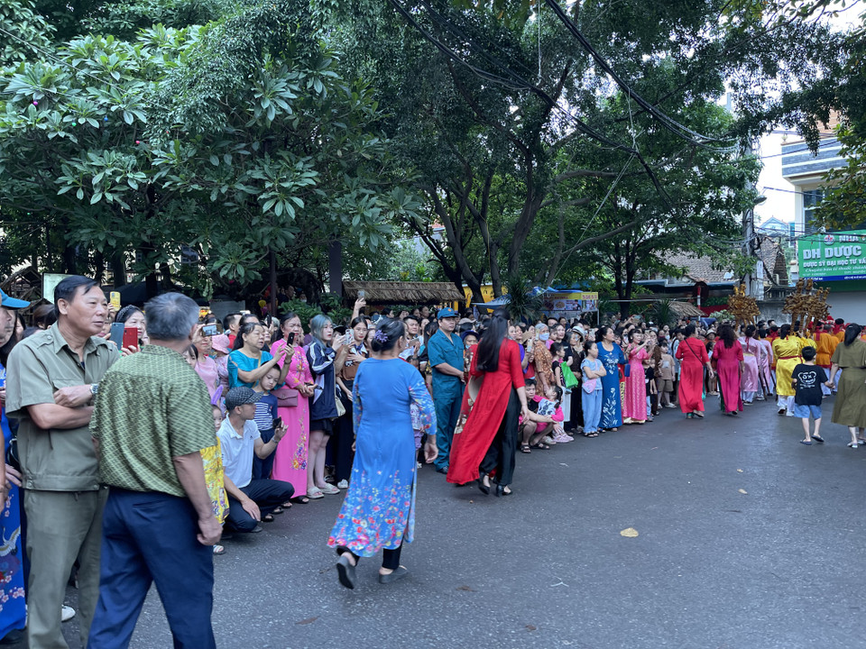 Hình ảnh người dân đang đứng xem lễ rước dọc theo đường đi của đoàn rước. (Ảnh: PV/Vietnam+)
