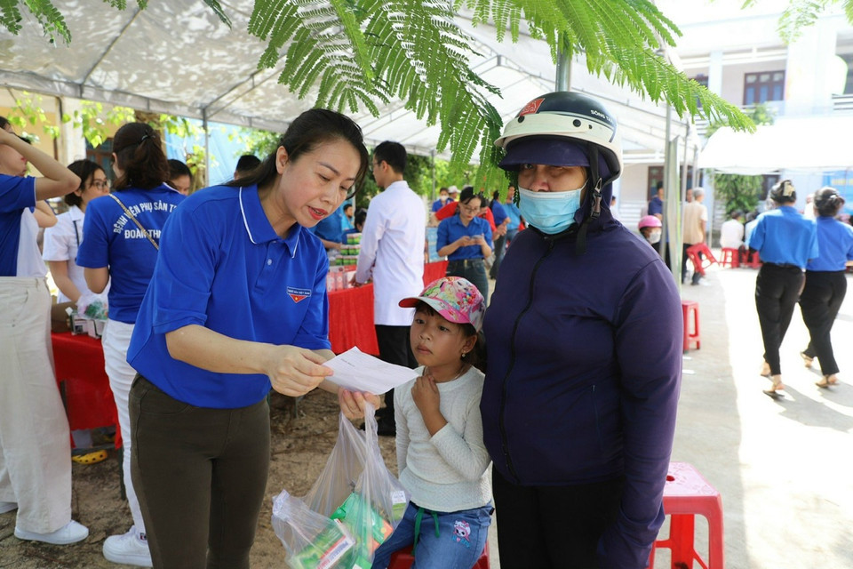 Nhân viên y tế phát thuốc và hướng dẫn sử dụng theo đơn thuốc cho người dân. (Ảnh: PV/Vietnam)