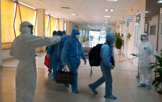 Nhân viên y tế hướng dẫn người dân vào khu vực cách ly. (Ảnh: PV/Vietnam+)