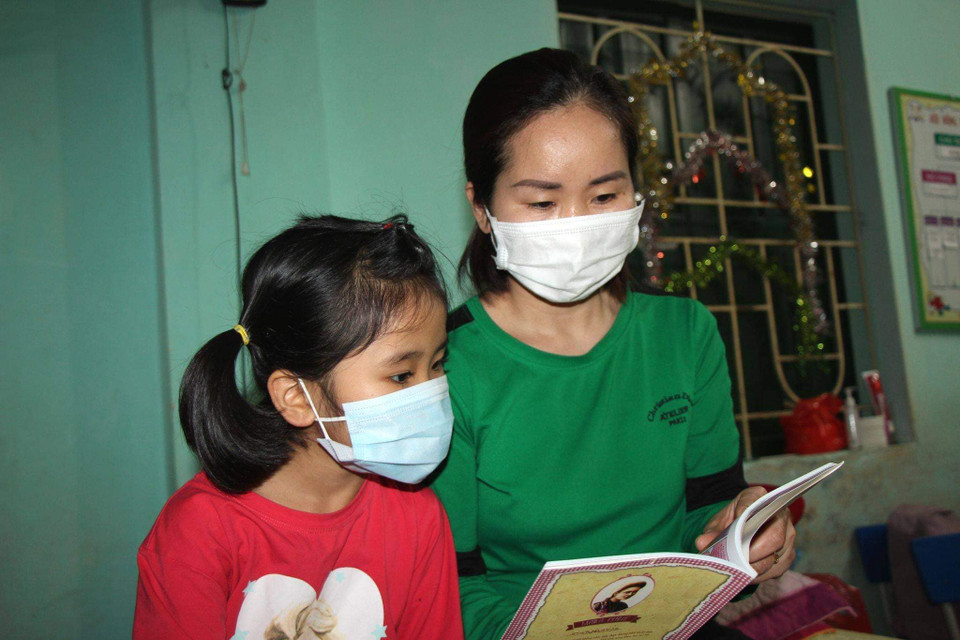 Một người mẹ vào khu cách ly cùng con. (Ảnh: PV/Vietnam+)